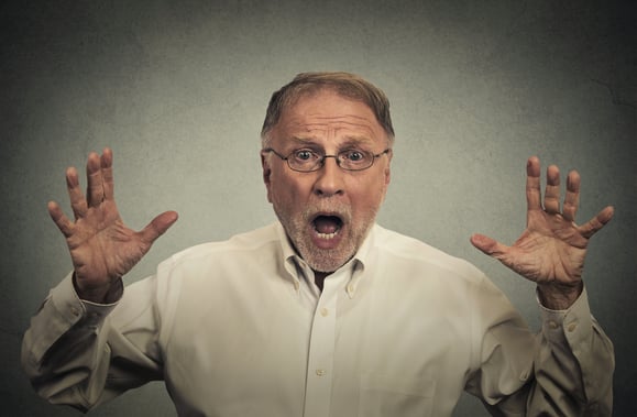 Closeup portrait shocked stunned surprised man eyes and mouth wide open, hands in air yelling screaming isolated on gray wall background. Negative human emotion facial expression feeling